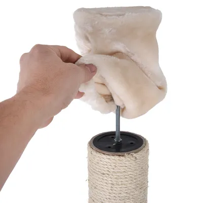 Assembling a scratching post element: hand pulls beige plush cover over metal rod and sisal column.