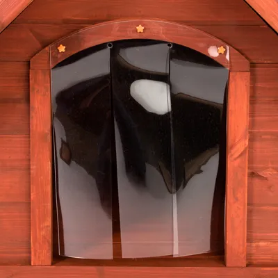 Puerta de láminas transparentes de plástico en caseta de madera para mascotas, con marco arqueado y detalles de estrellas en la parte superior.