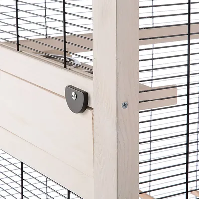 Detailweergave van een kooi met houten frame, metalen traliewanden en zwart sluitsysteem.