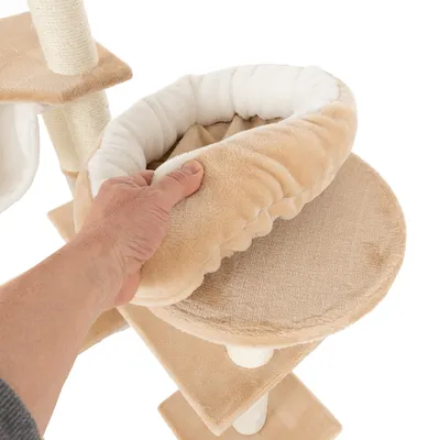 Hand showing removable, padded cushion on a cat tree platform. Beige fabric with visible white inner padding.