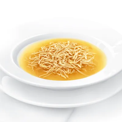 Cuenco blanco con caldo claro y finas tiras de pollo, servido en un plato blanco.