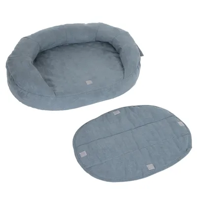 Ovales, blaues Haustierbett mit abnehmbarem, gepolstertem Kissen. Beide Teile aus Stoffmaterial sichtbar.