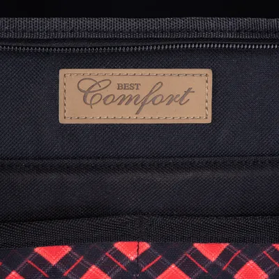 Étiquette en cuir cousue avec le texte « BEST Comfort » sur tissu noir, motif à carreaux rouges et noirs visible en bas de l’image.