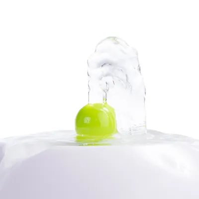 Nahaufnahme eines grünen Balls in einem Wasserstrahl, Teil eines Trinkbrunnens für Haustiere.