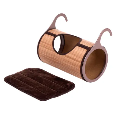 Tunnel cylindrique en bois avec deux crochets latéraux et une ouverture centrale, accompagné d’un coussin rectangulaire marron en tissu visible à côté.