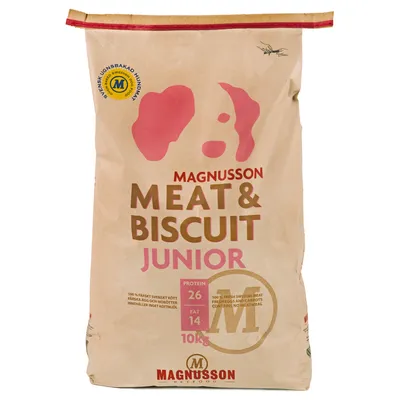 Sacco da 10 kg Magnusson Meat & Biscuit Junior, proteine 26%, grassi 14%. Testo visibile: '100% fresh Swedish meat, fresh eggs and carrots, containing no meatmeal'.