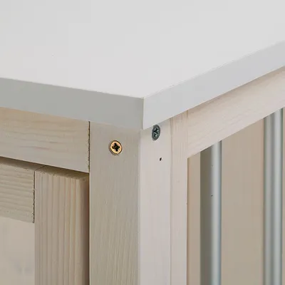 Detailweergave van een houten frame met metalen staven en wit tafelblad, bevestigd met schroeven.