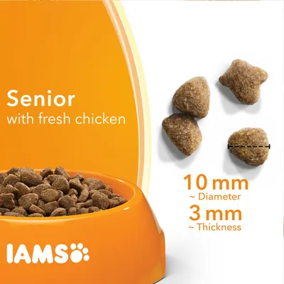 IAMS Senior with fresh chicken -kuivaruokanappuloita, halkaisija noin 10 mm ja paksuus noin 3 mm. Näkyvissä oranssi ruokakuppi ja kolme nappulaa erikseen.