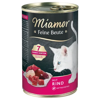 Miamor Feine Beute kissan märkäruoka, purkki. Teksti: 7 Sieben Sorten Fleisch & Innereien, mit Rind, getreidefrei. Kuvassa valkoinen kissa ja lihaa lautasella.