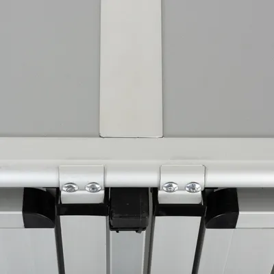 Dettaglio di giunzione in metallo con viti e parti nere in plastica, vista dall’alto. Materiali: metallo e plastica visibili.