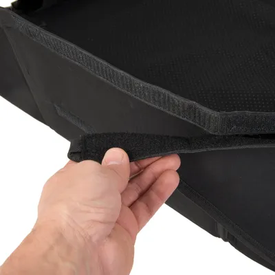 Närbild av en svart väska med kardborreförslutning som öppnas av en hand.