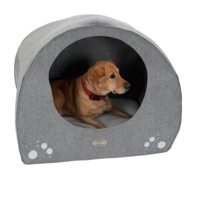 Hund in grauer Hundehöhle mit Pfotenmotiv und gepolsterter Liegefläche. Sichtbares Logo: Trixie.