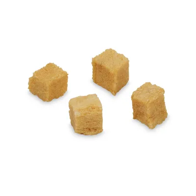 Quattro cubetti di snack per animali, colore beige chiaro, senza confezione visibile su sfondo bianco.