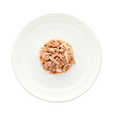 Porce drceného masa na bílém talíři, detailní pohled na strukturu a barvu produktu.