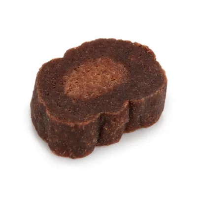 Close-up of a brown, meat-shaped dog snack with a soft filling in the centre.