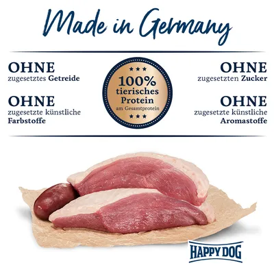 Made in Germany. Ohne zugesetztes Getreide, Zucker, künstliche Farbstoffe und Aromastoffe. 100% tierisches Protein am Gesamtprotein. Happy Dog Logo sichtbar.