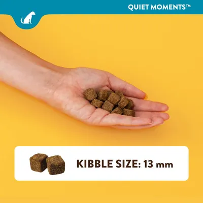 Ruka držiaca kockové granule, text: QUIET MOMENTS, KIBBLE SIZE: 13 mm. Veľkosť granúl je 13 mm.