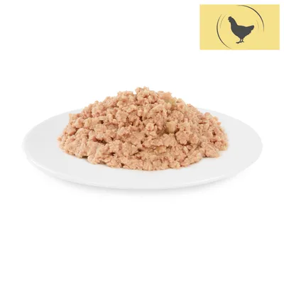 Close-up of shredded wet food on a white plate. Yellow symbol with black chicken in the top right.