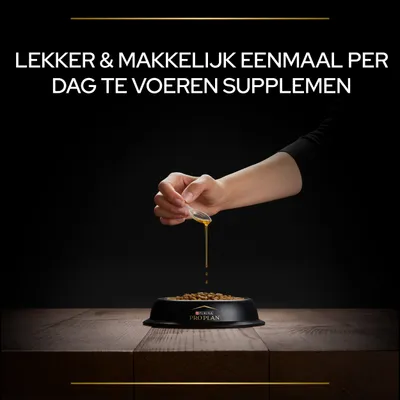 Tekst: Lekker & makkelijk eenmaal per dag te voeren supplement. Hand giet vloeistof over brokjes in Purina Pro Plan voerbak.