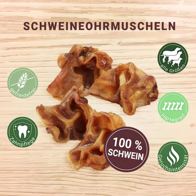 Fyra torkade gristugg med text: SCHWEINEOHRMUSCHELN, 100 % SCHWEIN, getreidefrei, Zahnpflege, alle Größen, Härtegrad, Geruchsintensität. Text på tyska.
