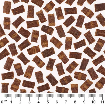 Nahaufnahme von braunen Snackstücken mit Massstab in Zentimetern, zeigt Grösse und Form der Stücke.