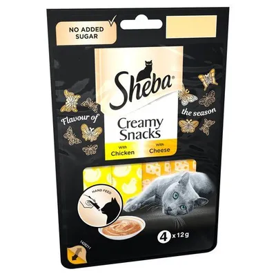 Sheba Creamy Snacks with Chicken and Cheese, no added sugar, 4 x 12g. Visible text: flavour of the season, hand feed. Image shows cat and snack illustration on packaging.